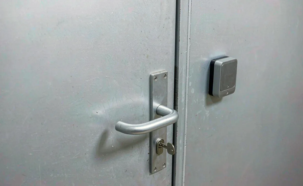 金属门板上的机械钥匙与门旁的门禁读头